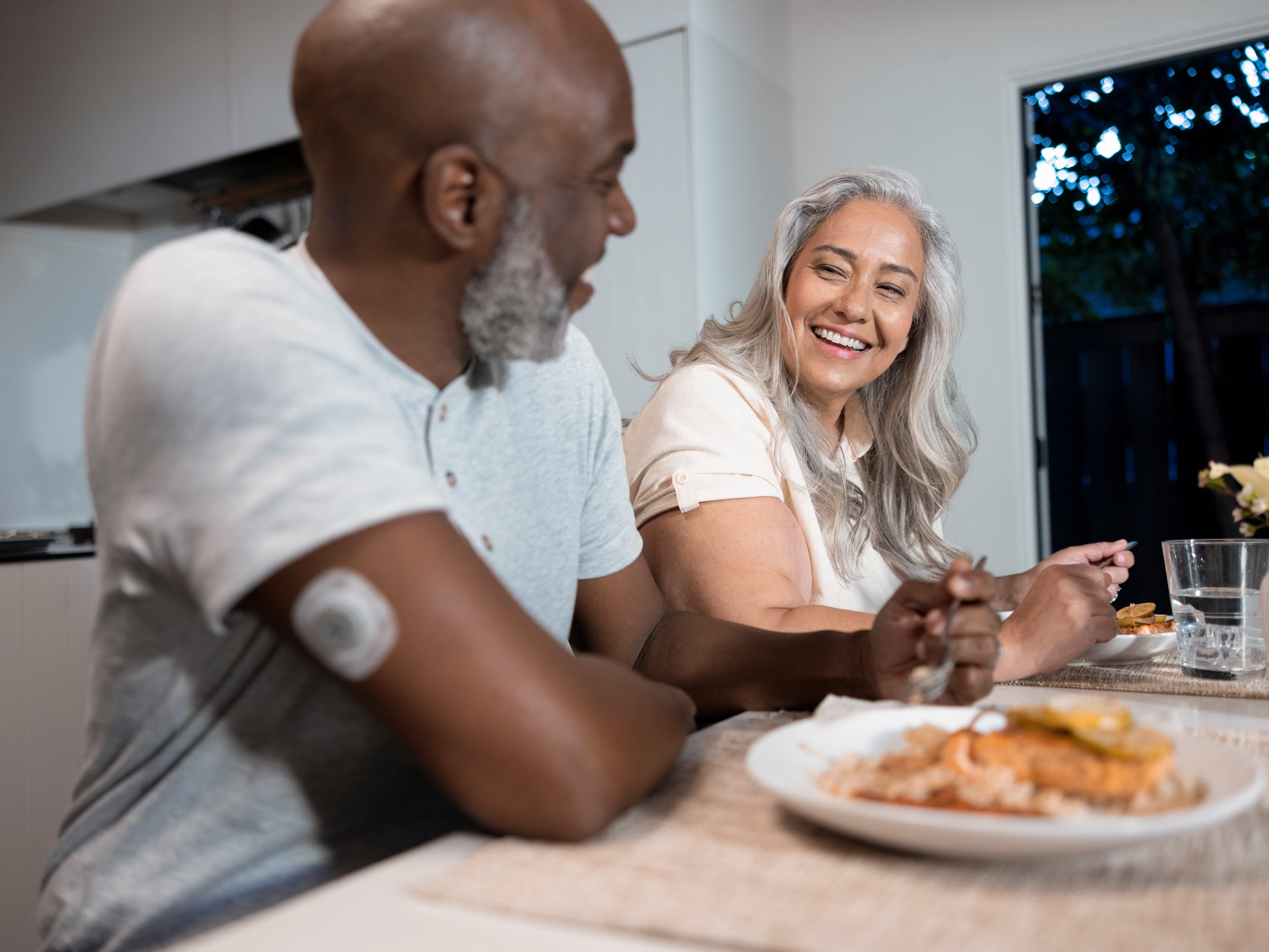 Man and woman eating dinner together wearing Stelo