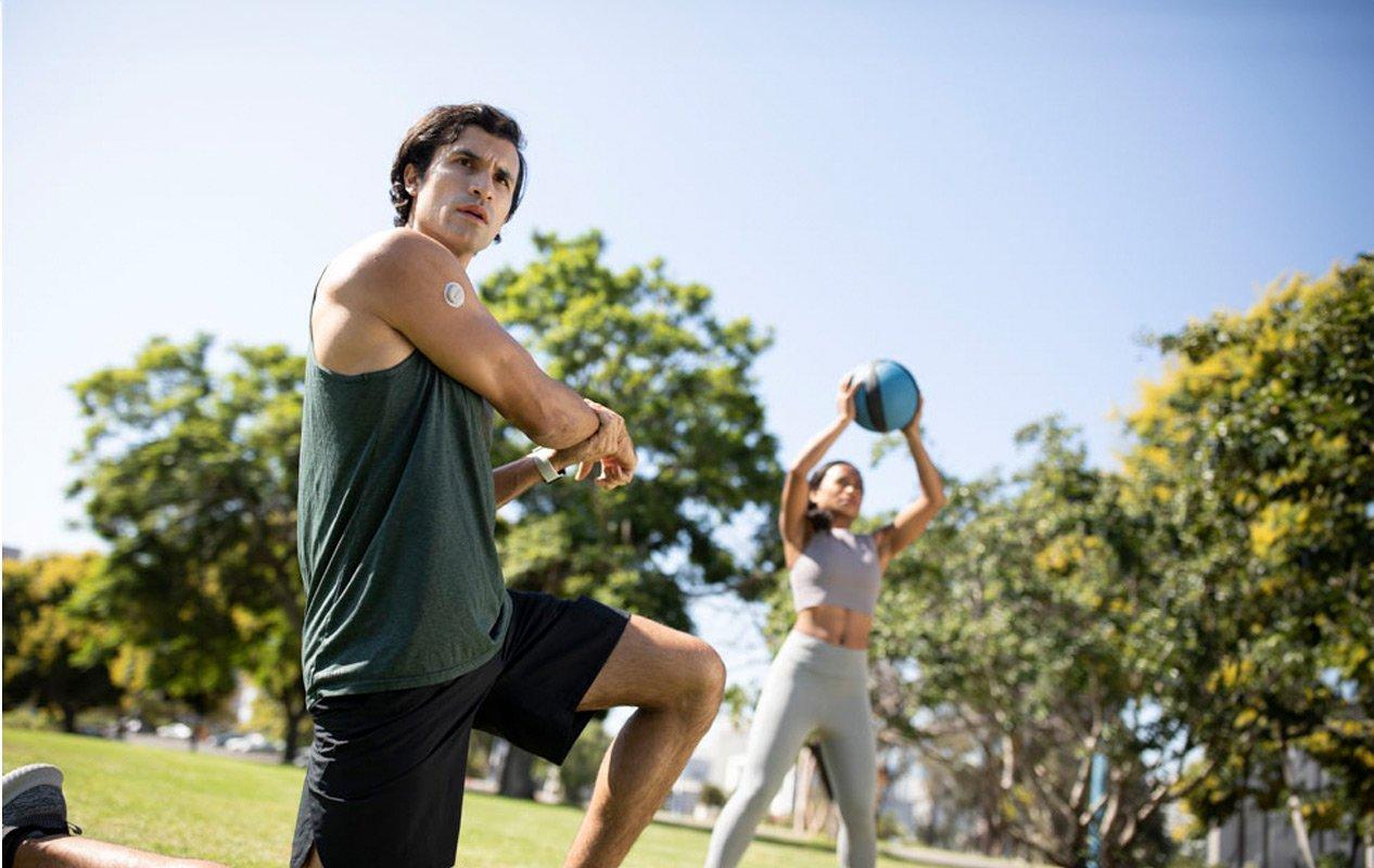 Una giovane coppia che fa stretching al parco in una giornata di sole