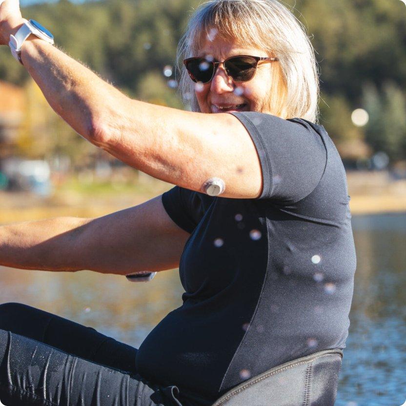 Someone wearing a Dexcom G7 on the back of their arm while kayaking