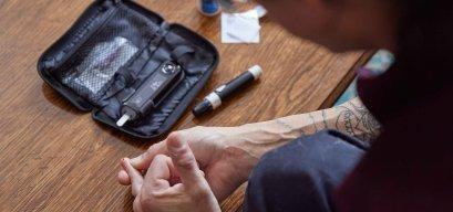 A person living with diabetes poking their finger to test their blood sugar