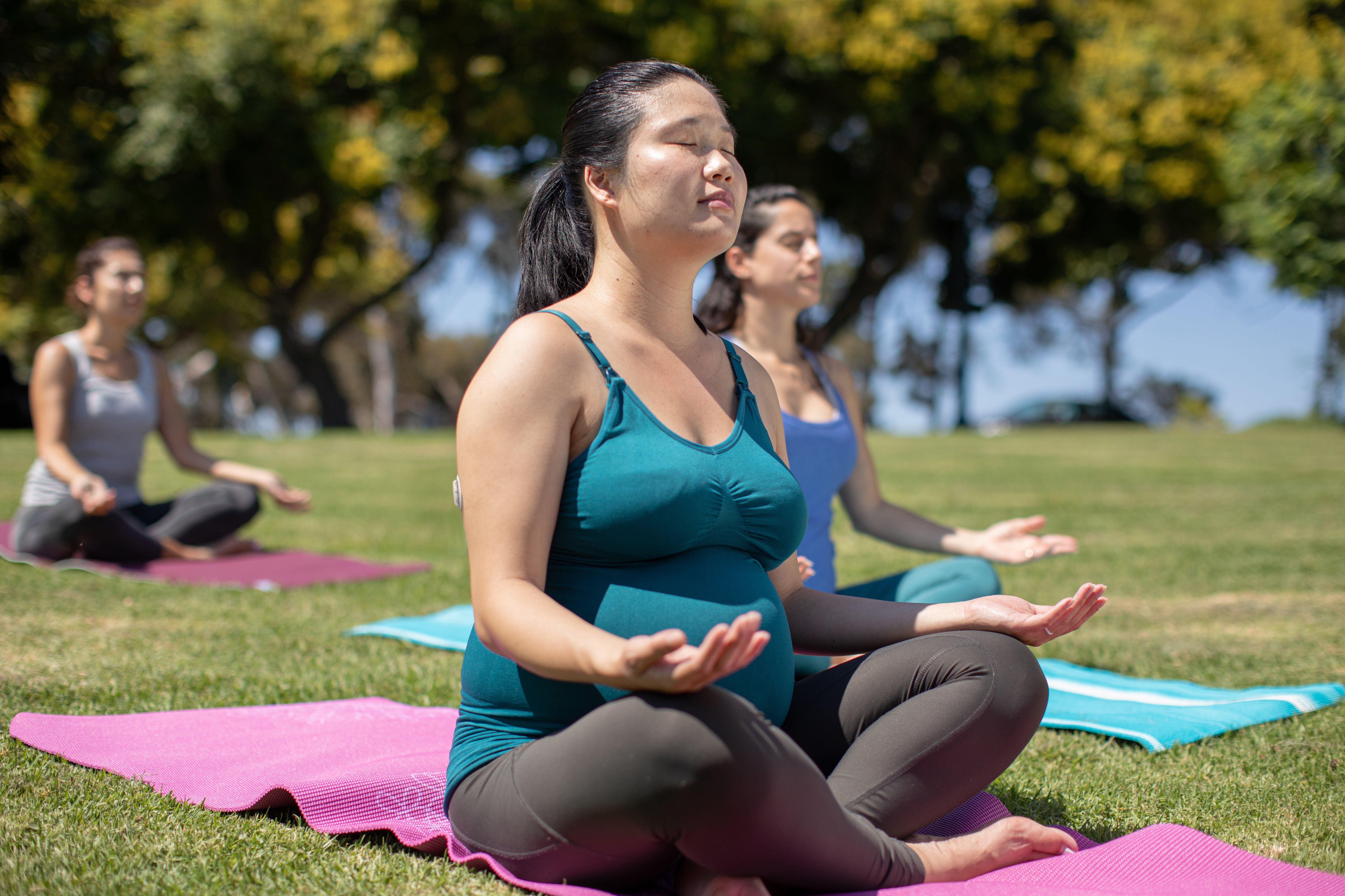 Pregnant woman doing yoga while wearing the dexcom sensor
