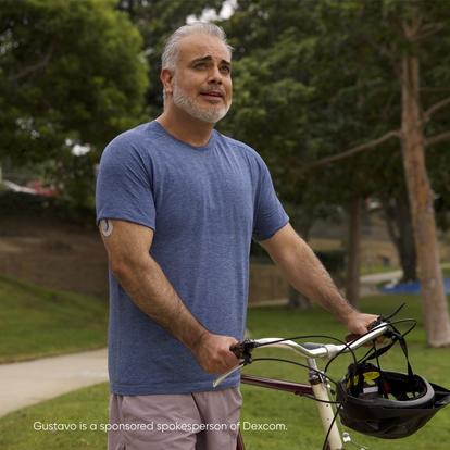 Man holding bicycle handles wearing a Dexcom Continuous glucose monitoring device