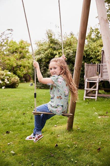 Girl with diabetes on a swing wearing a diabetic patch