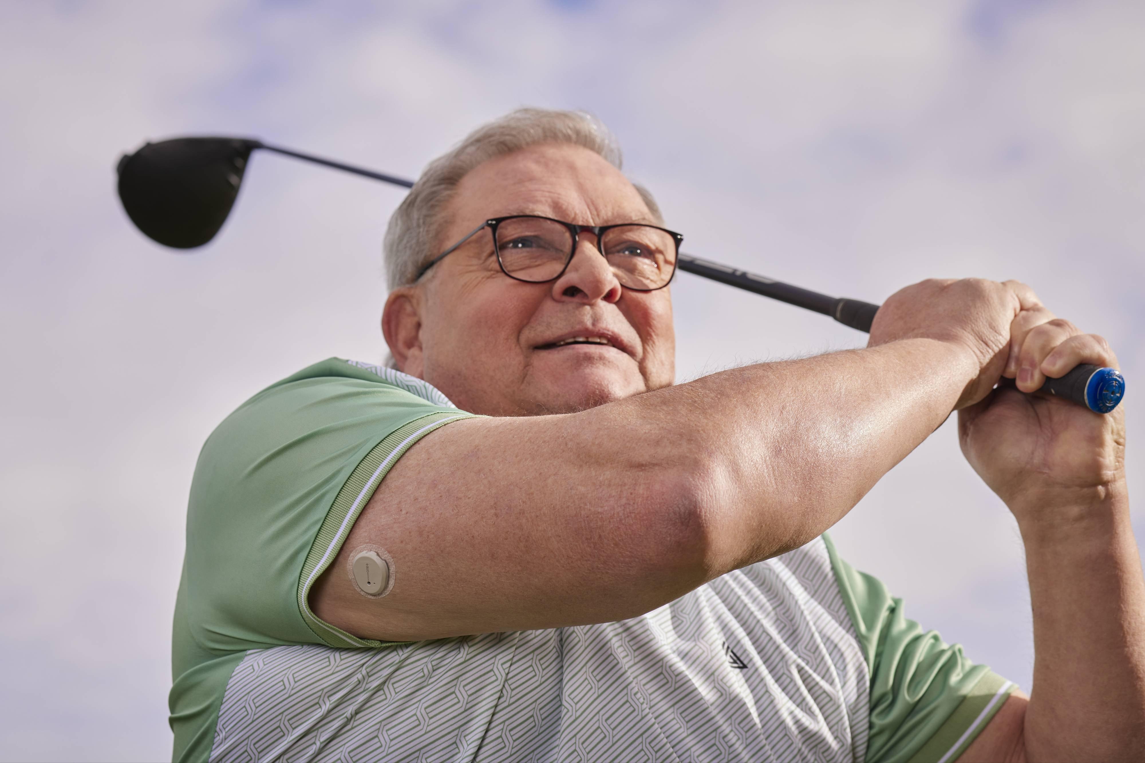 Man holding bicycle handles wearing a Dexcom Continuous glucose monitoring device