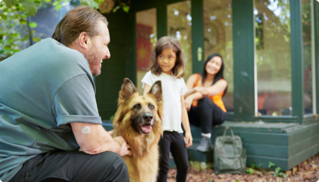 Dad wearing Dexcom ONE+ device outside with family