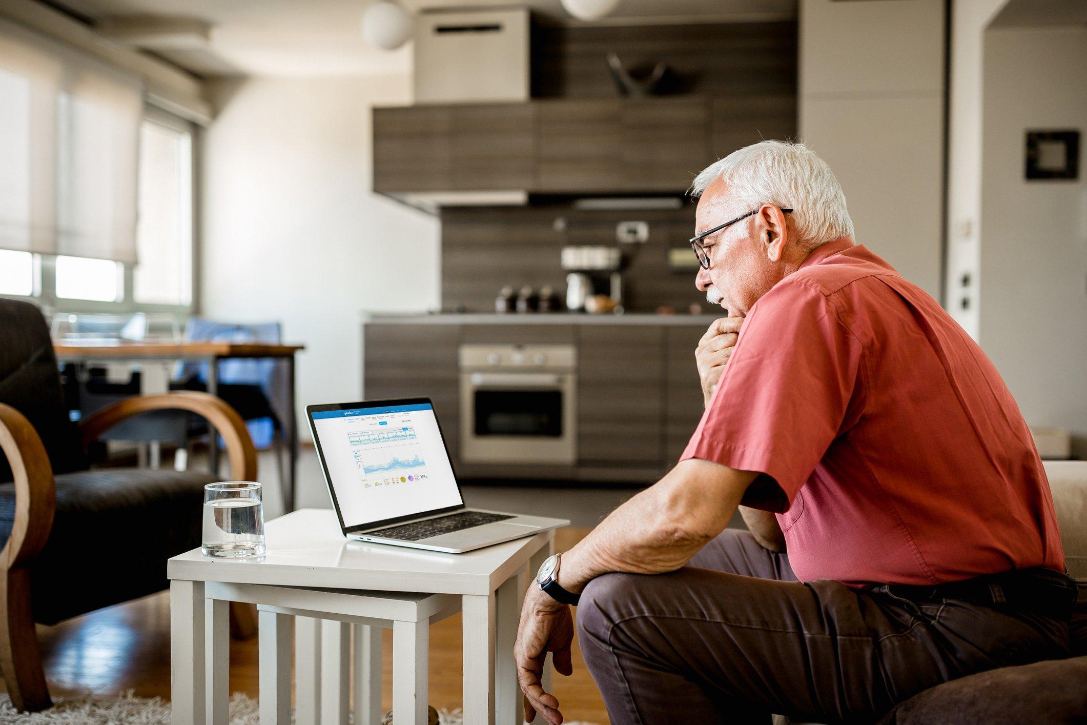 Man looking at synced CGM data on a laptop