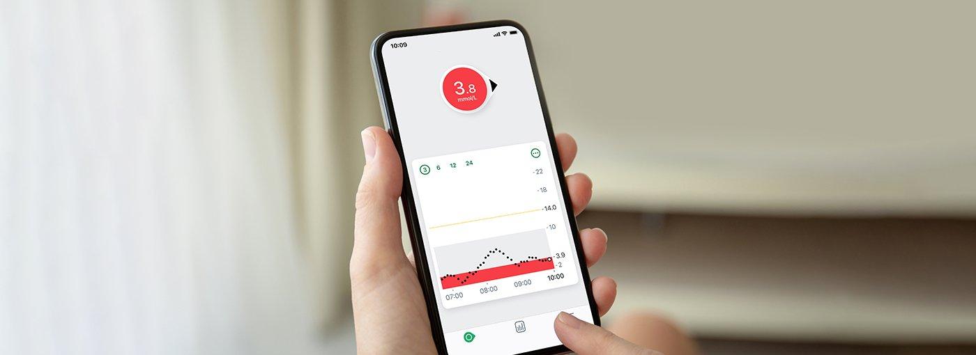 Person holding a receiver with cgm data displayed