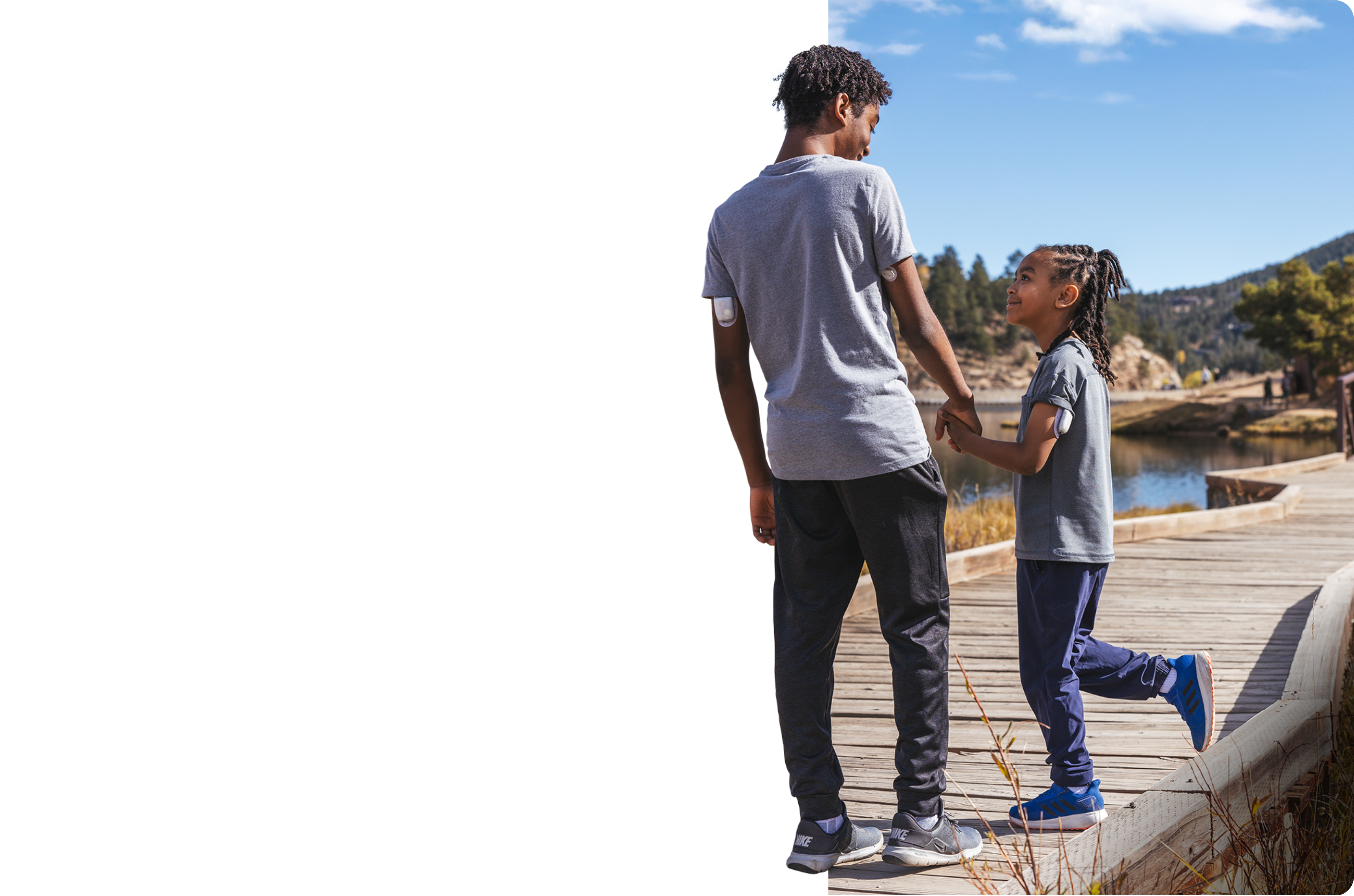 Brothers walking along a wooden path wearing the Dexcom G7 and Omnipod 5