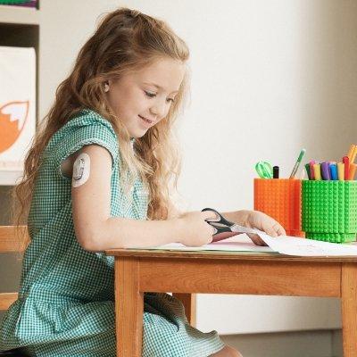 Young girl wearing a Dexcom sensor at school