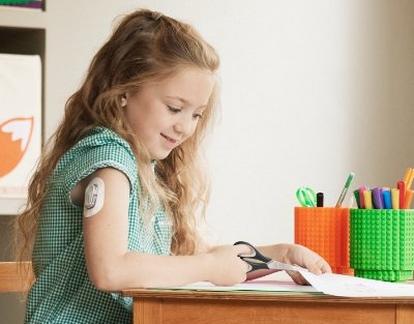 Young girl wearing a Dexcom sensor at school