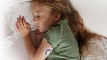 Young girl with paediatric diabetes who is sleeping and wearing a Dexcom sensor