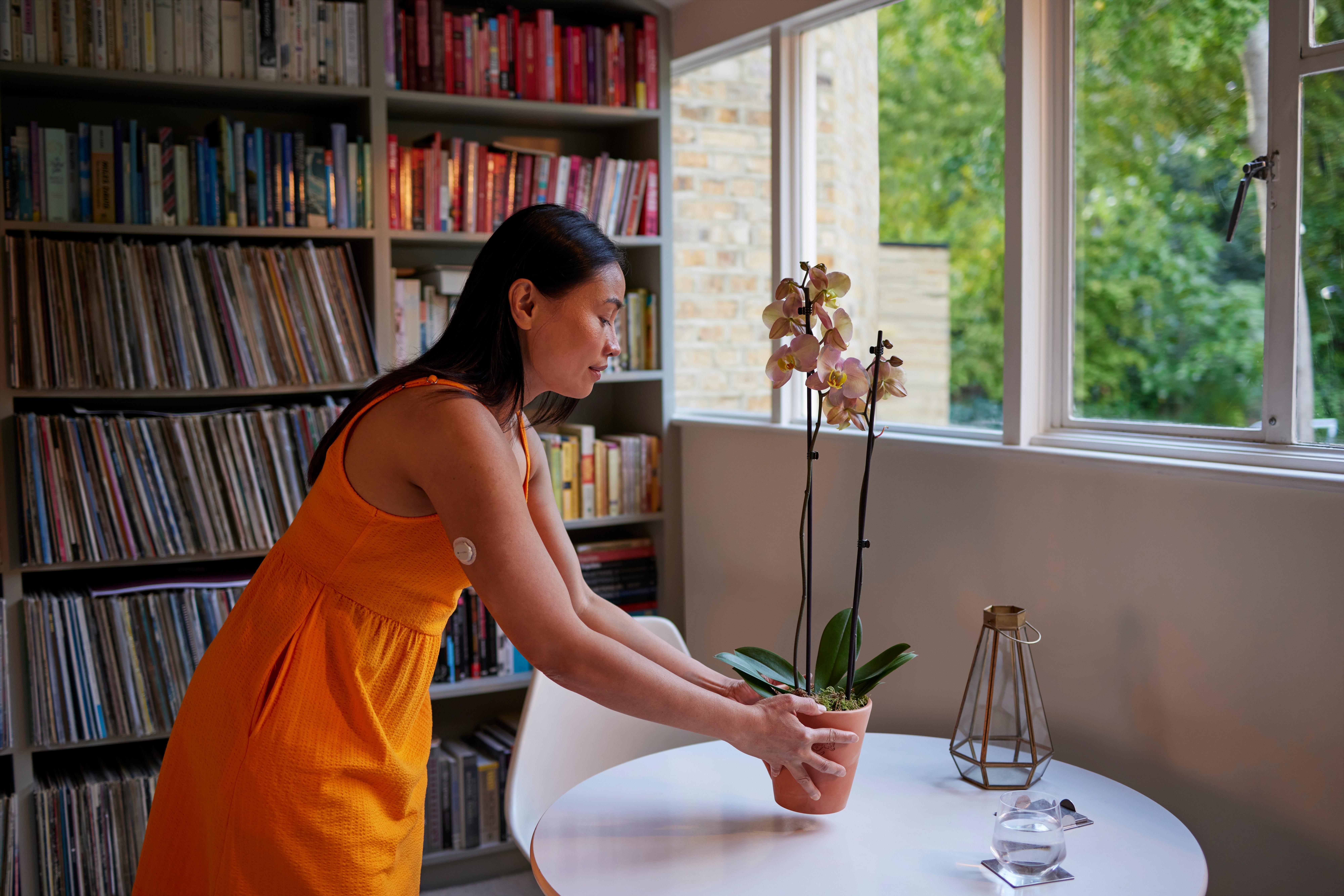 girl-wearing-cgm-touching-a-pot-plant