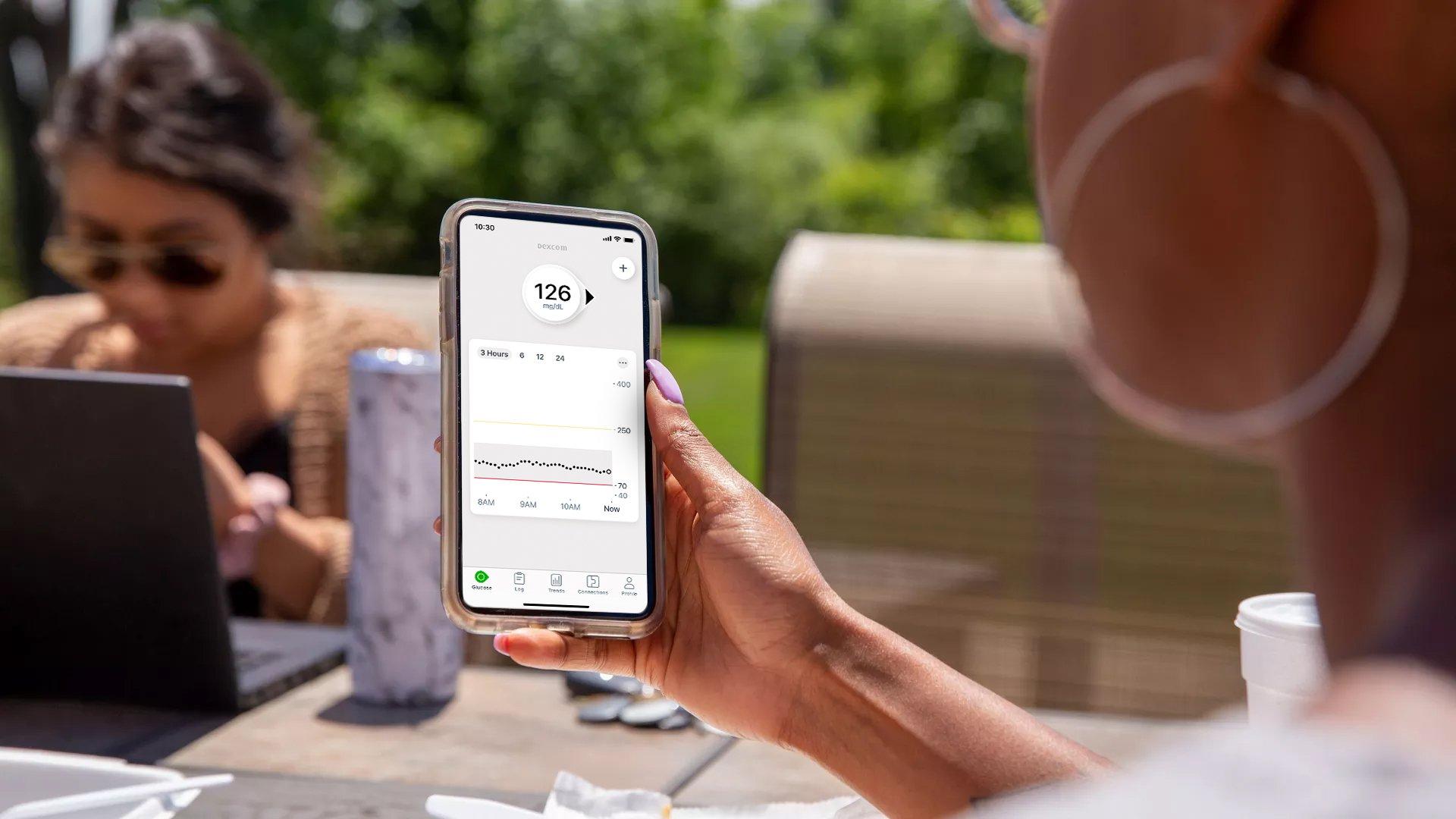 hand holding smart phone with dexcom app screen