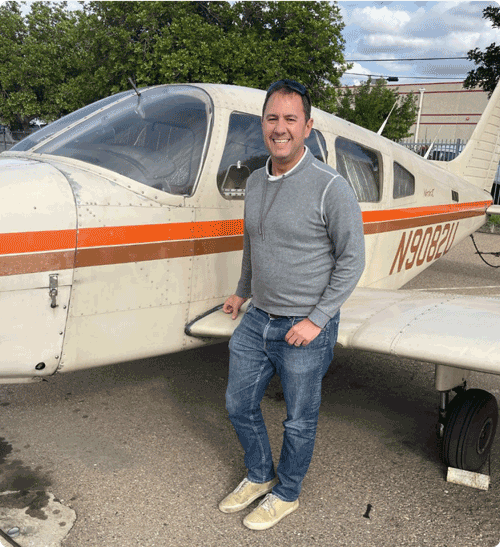 Heyman standing near a small plane