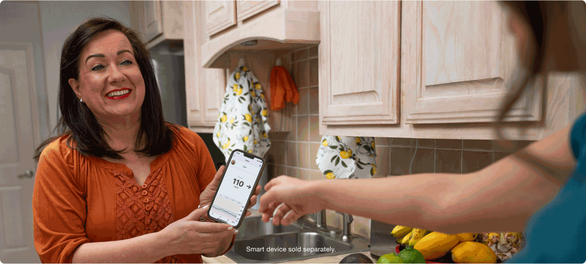 Annie showing Glucose readings to a friend in the kitchen