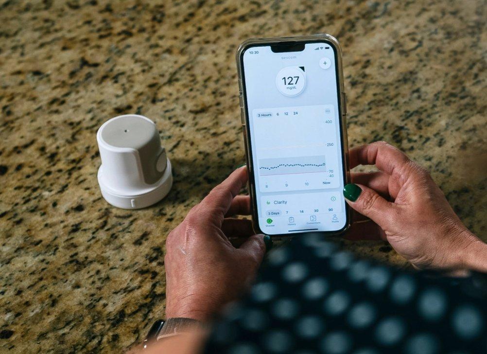 Biz Velatini monitors her glucose readings on her smart phone using Dexcom's CGM App
