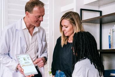 Doctor showing Zola her glucose readings and historical data on an Ipad