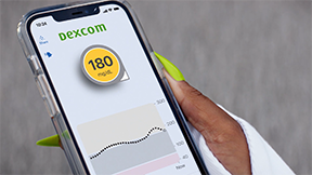 Hand holding smartphone showing dexcom g6 app