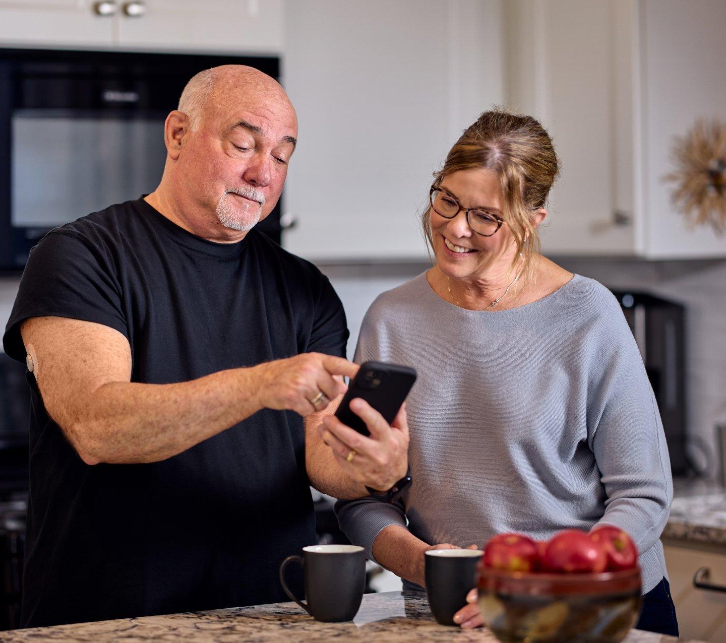 man and woman looking at phone smiling