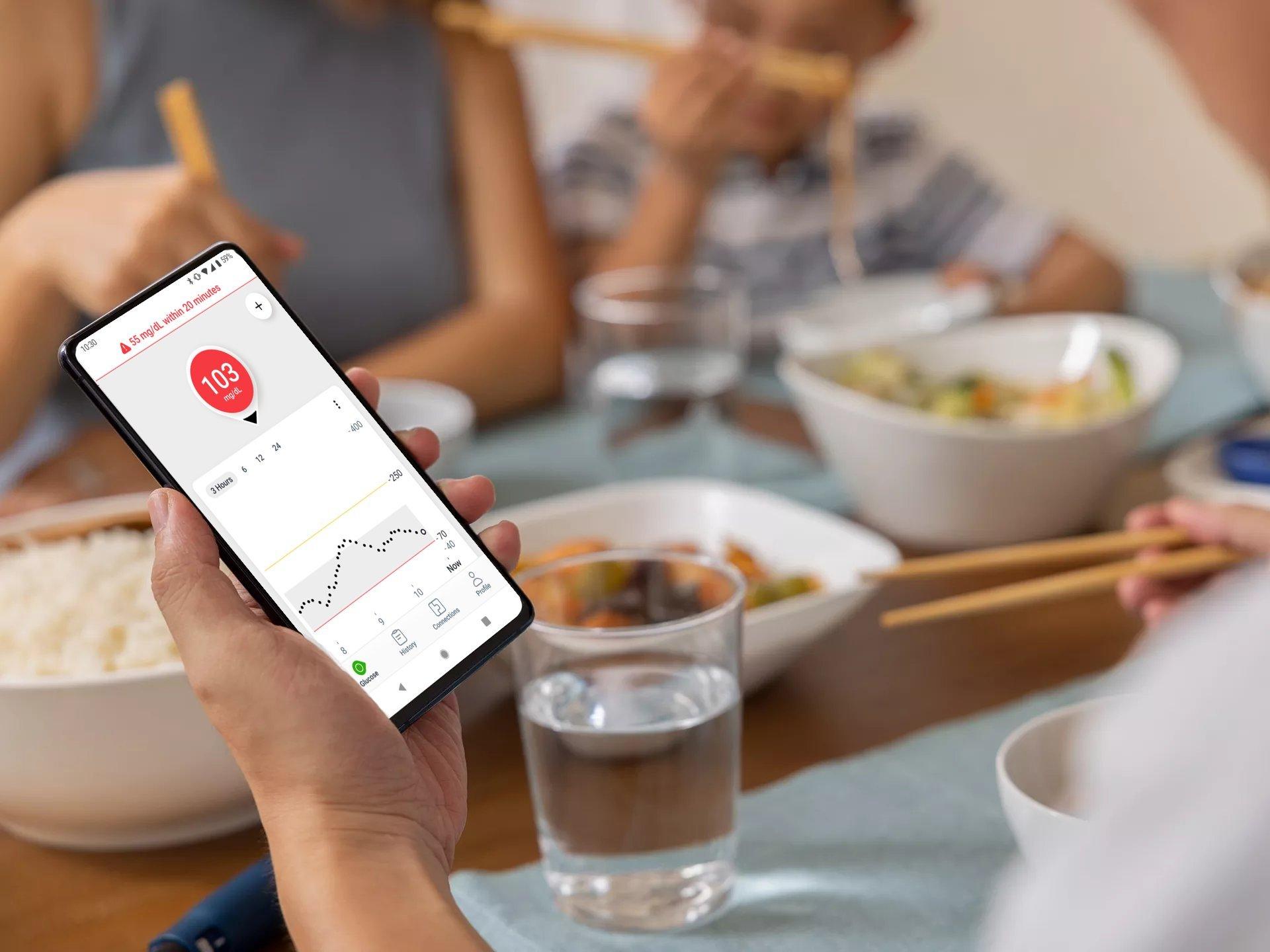 image of a hand holding a smart device with the urgent low message appearing