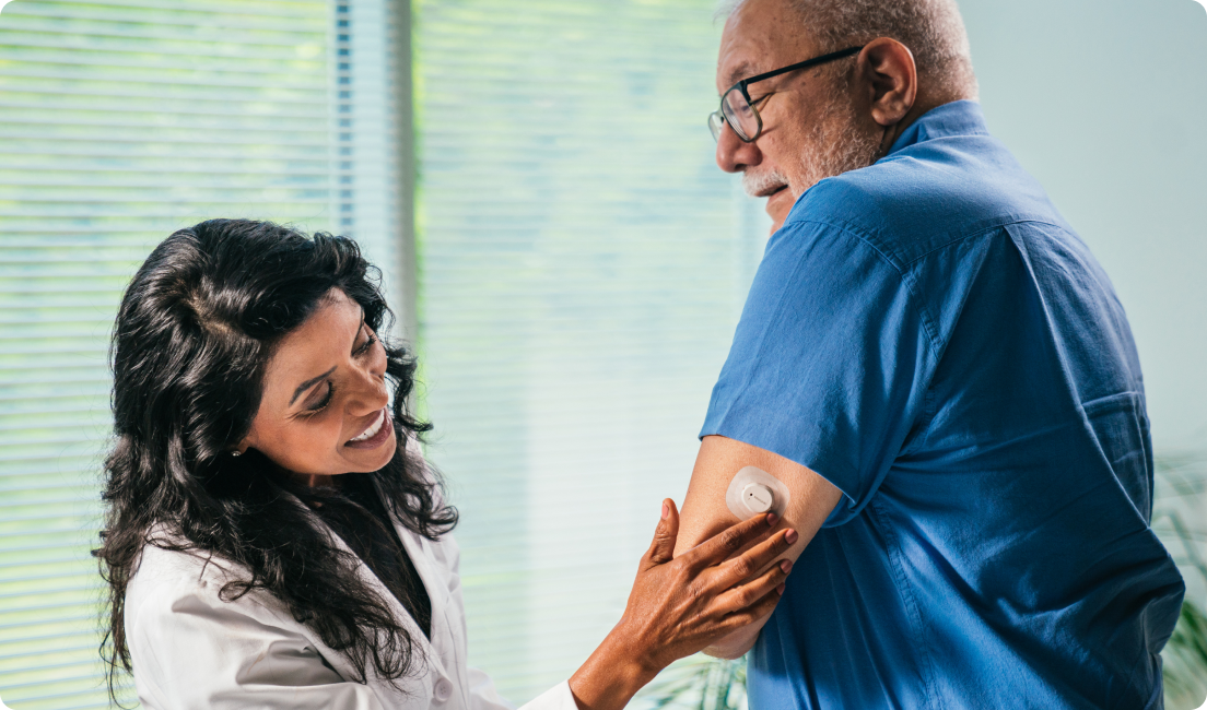 doctor checking dexcom cgm on mans arm