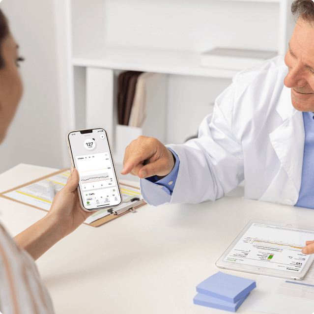 doctor and patient looking at dexcom app screen in office