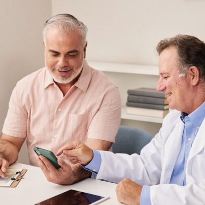 Image of doctor and patient looking at a smartphone with the Dexcom G7 app