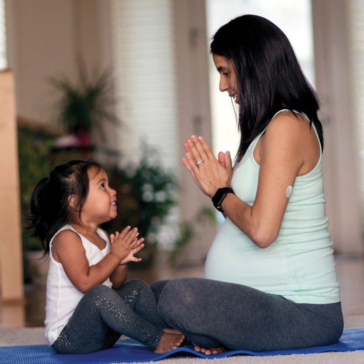 pregnant woman doing yoga with daughter
