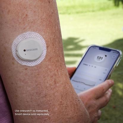Woman wearing Dexcom G7 CGM on arm with phone app screen in background