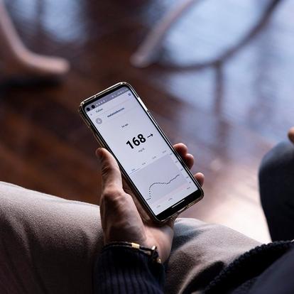 man holding smart phone with share settings screen