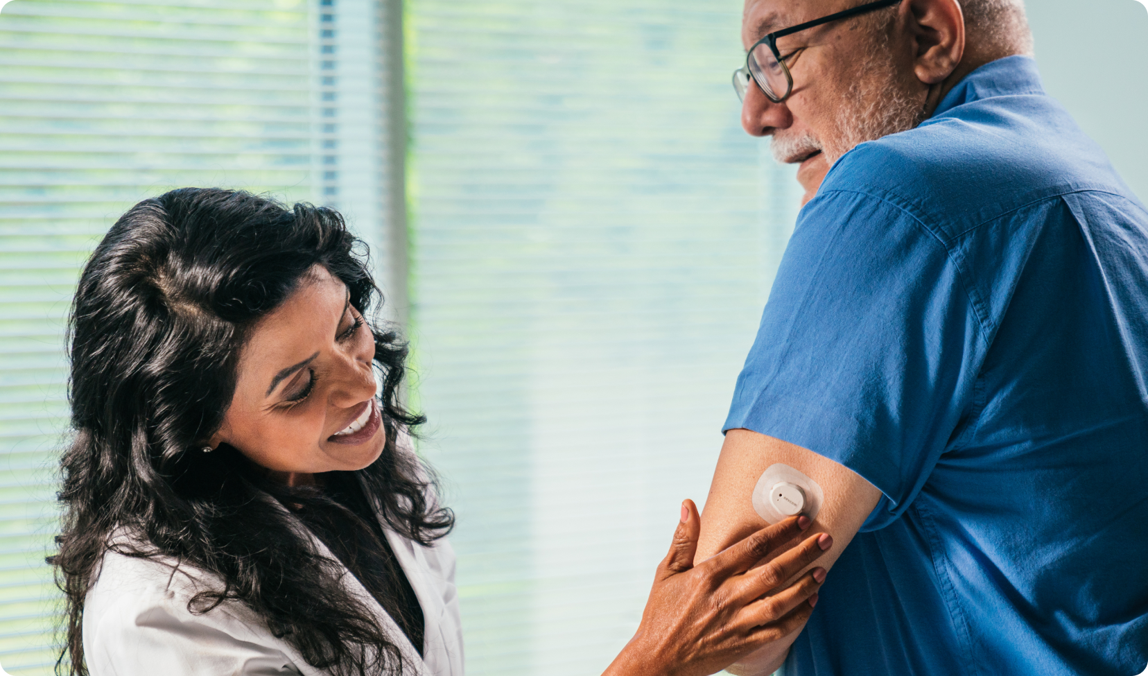 doctor inspecting sensor on mans arm