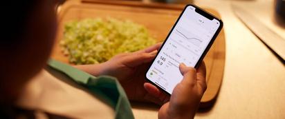 Woman wearing Dexcom G7 and checking her glucose time in range.