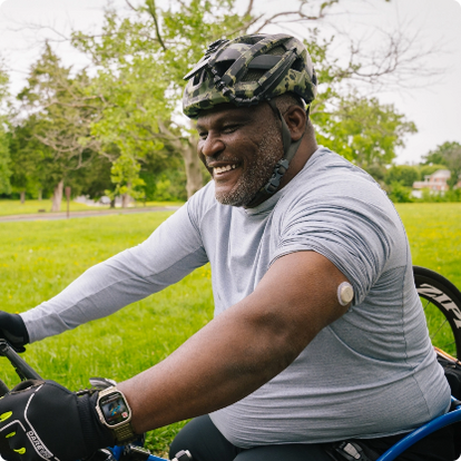 man riding his bike wearing a dexcom sensor on his arm