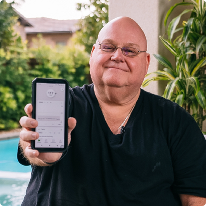 man holding a smart phone with dexcom app screen