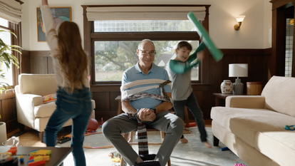 man playing with children in living room