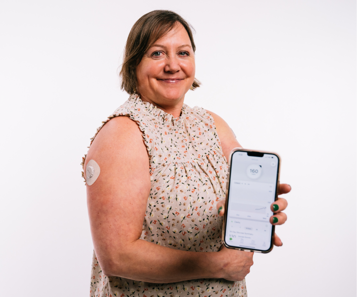 woman showing a phone screen of dexcom app