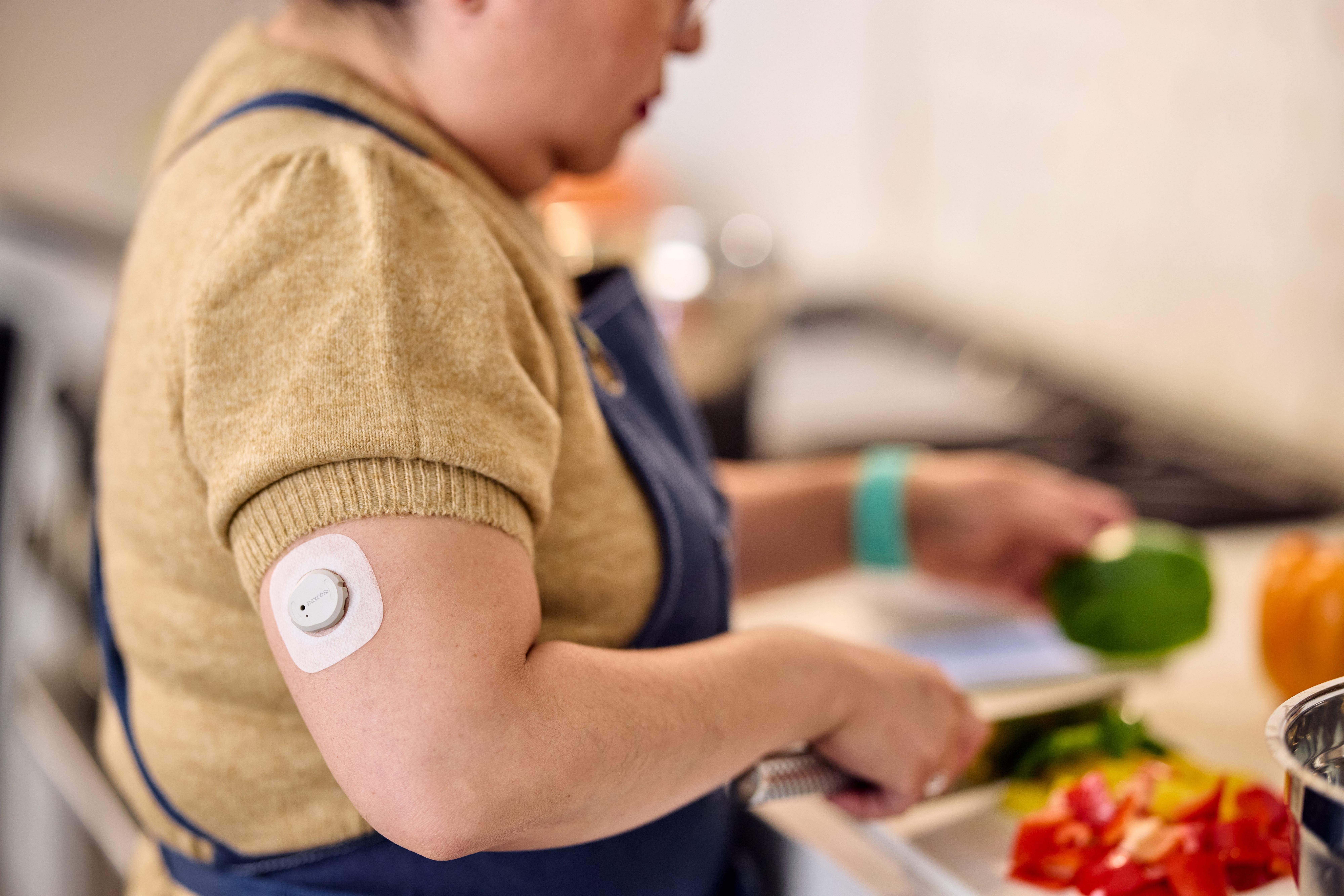 woman chopping food wearing dexcom patch