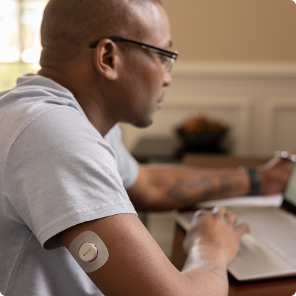 man working at desk wearing dexcom