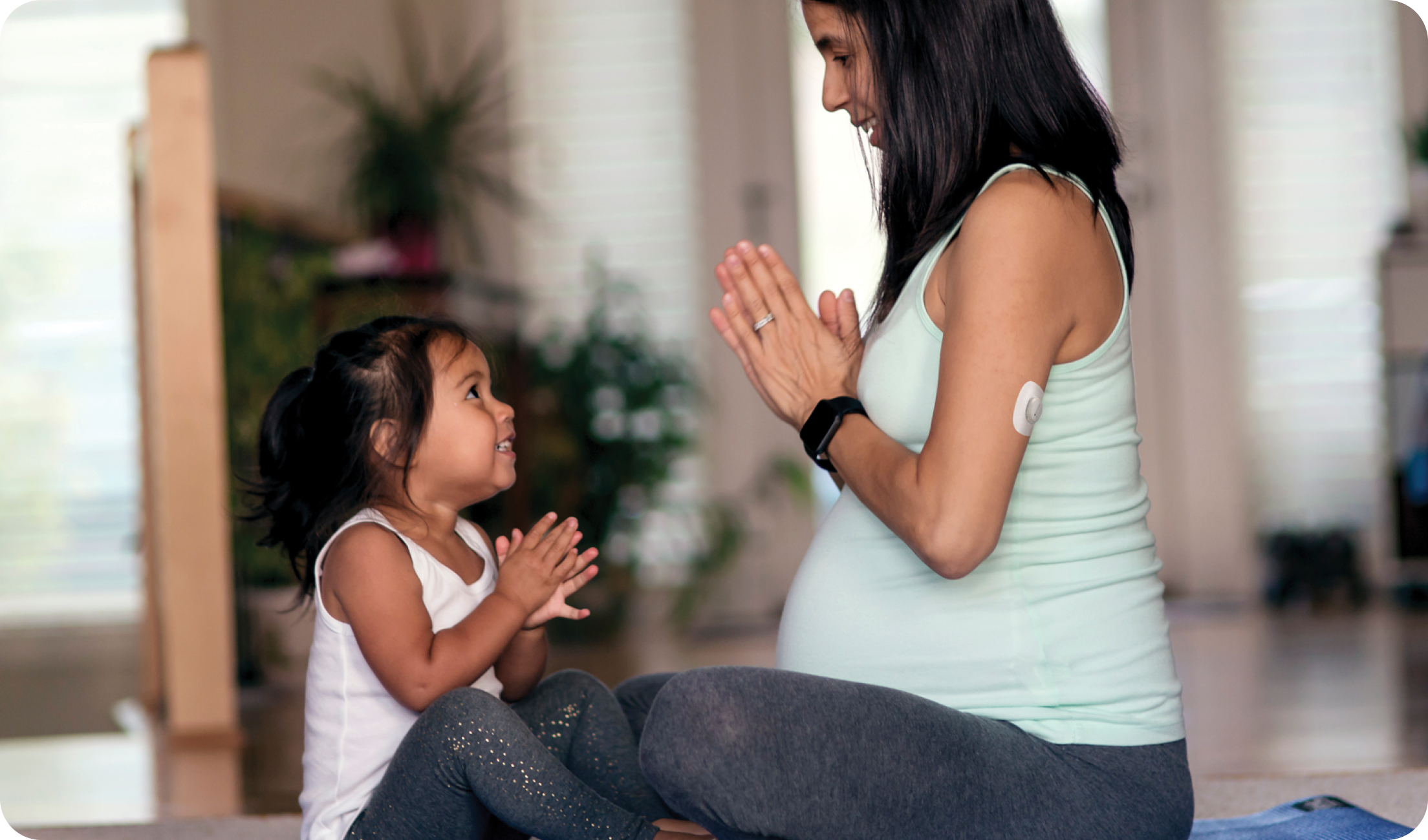 pregnant woman doing yoga with daughter