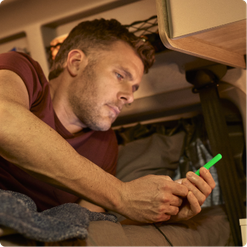 man looking at phone in bed