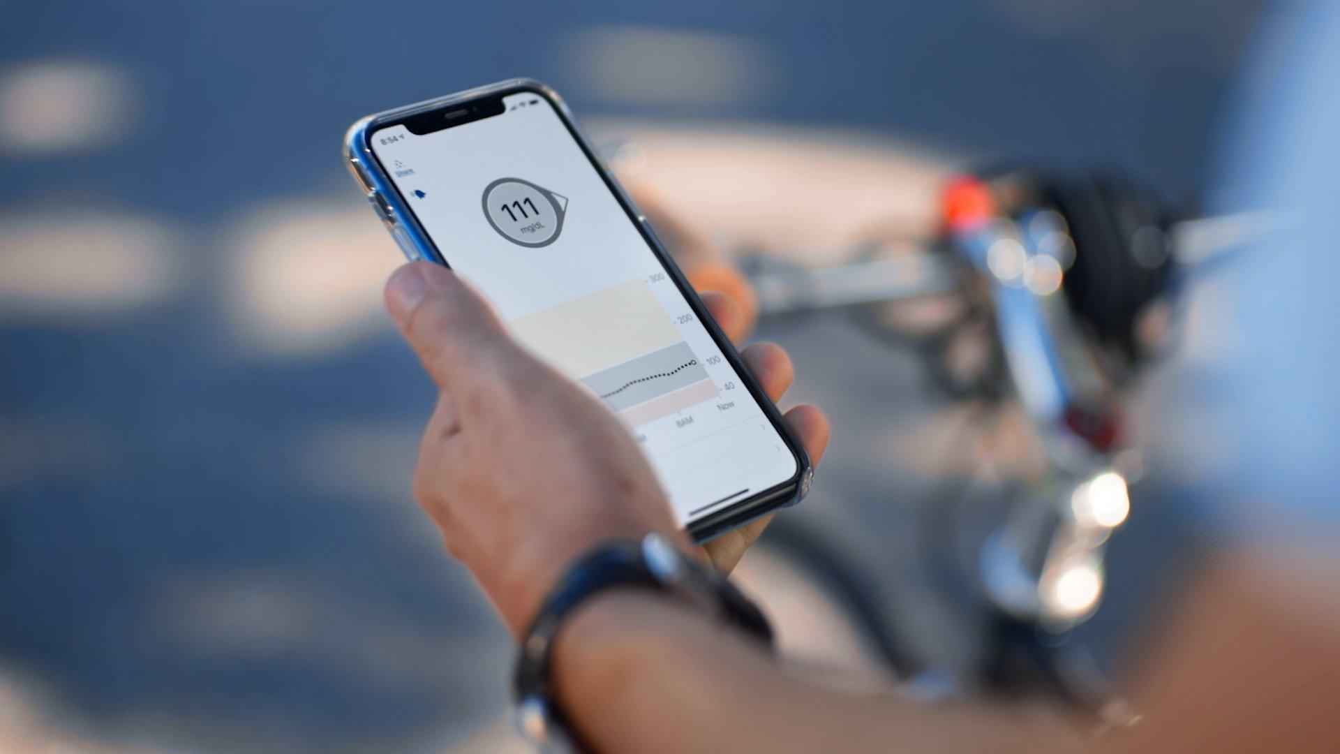 Dexcom G6 biker holding phone