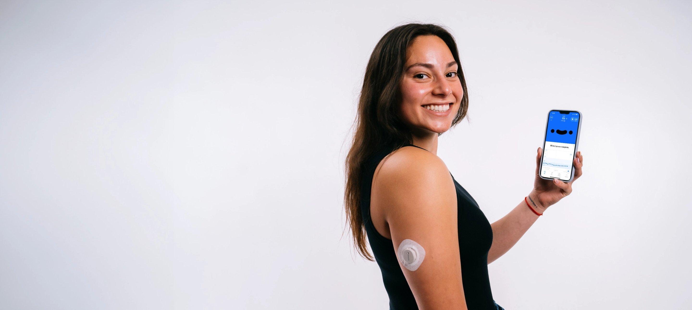 Woman wearing G7 back of arm with Happy Bob app on smartphone