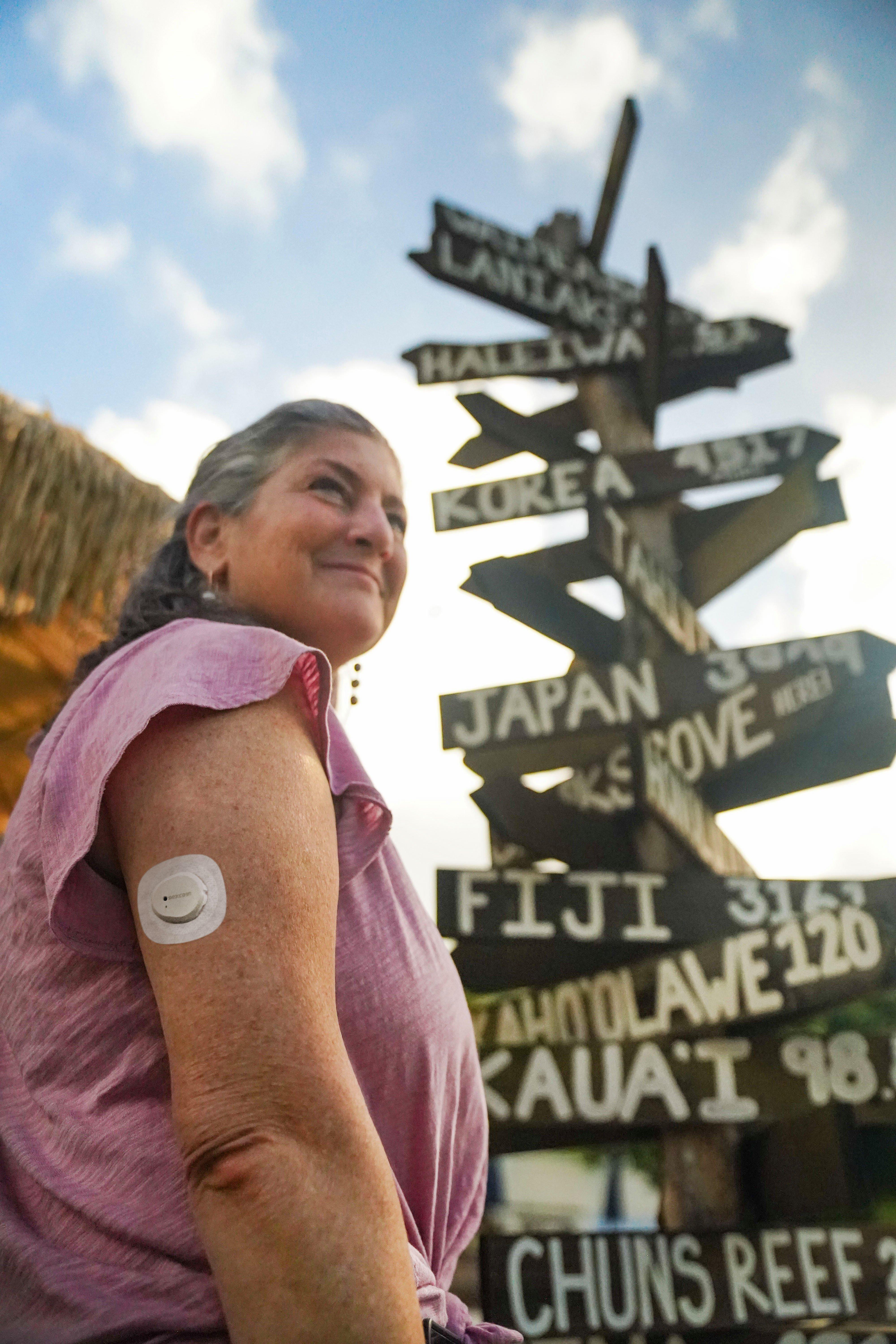 man riding surfboard in wave wearing dexcom g7 sensor