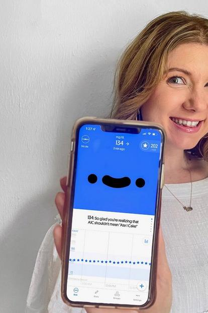 Woman holding phone with happybob screen