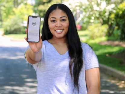 woman smiling showing her phone with dexcom app screen