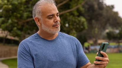 woman looking at smart phone with dexcom app screen showing