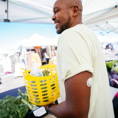 man at farmers marketing with dexcom sensor on arm