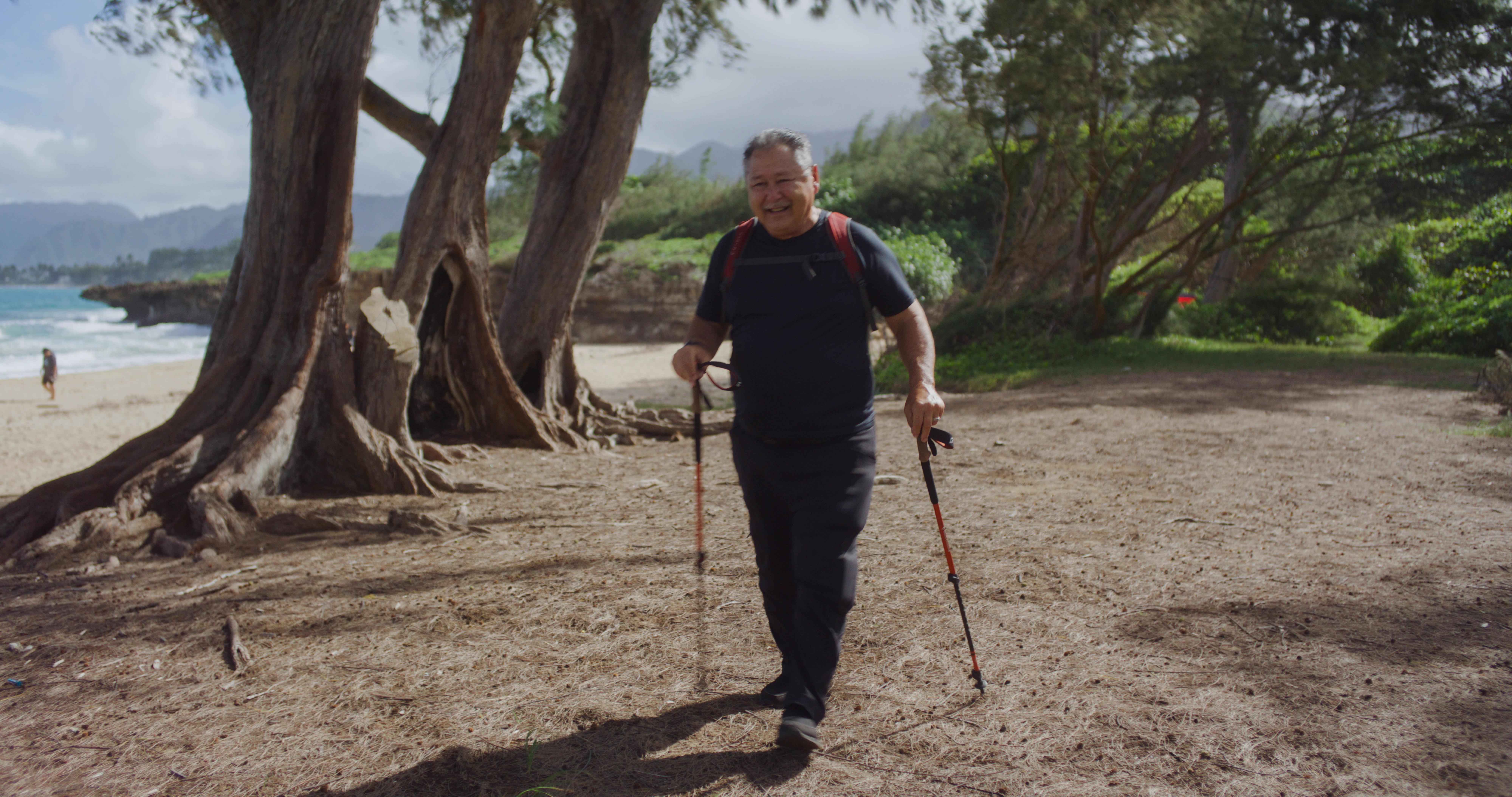 man walking on trail by beach