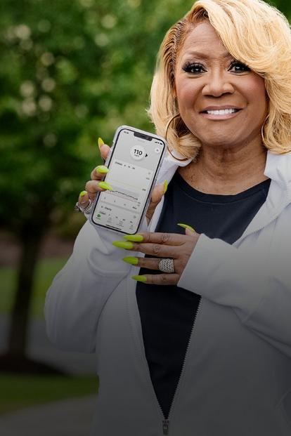 woman holding a smartphone with the dexcom app screen displayed