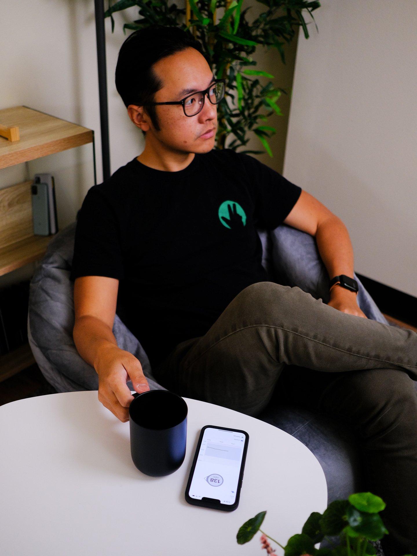 man sitting at table drinking coffee